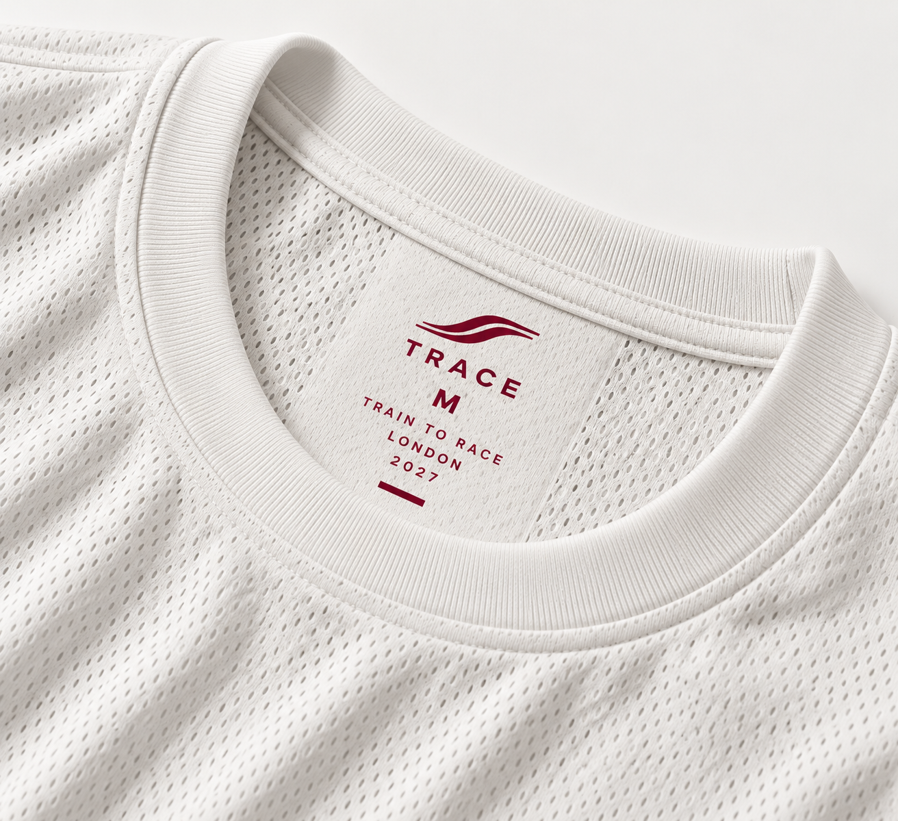 Close-up of the white long sleeve's mesh neckline and TRACE label
